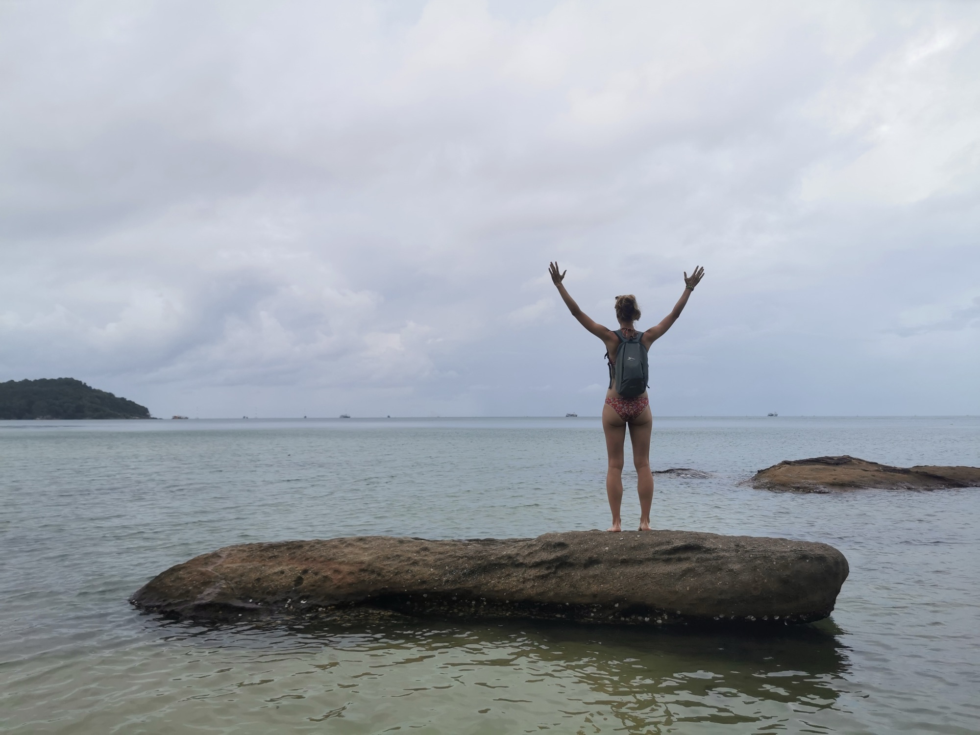 Laura encima piedra playa