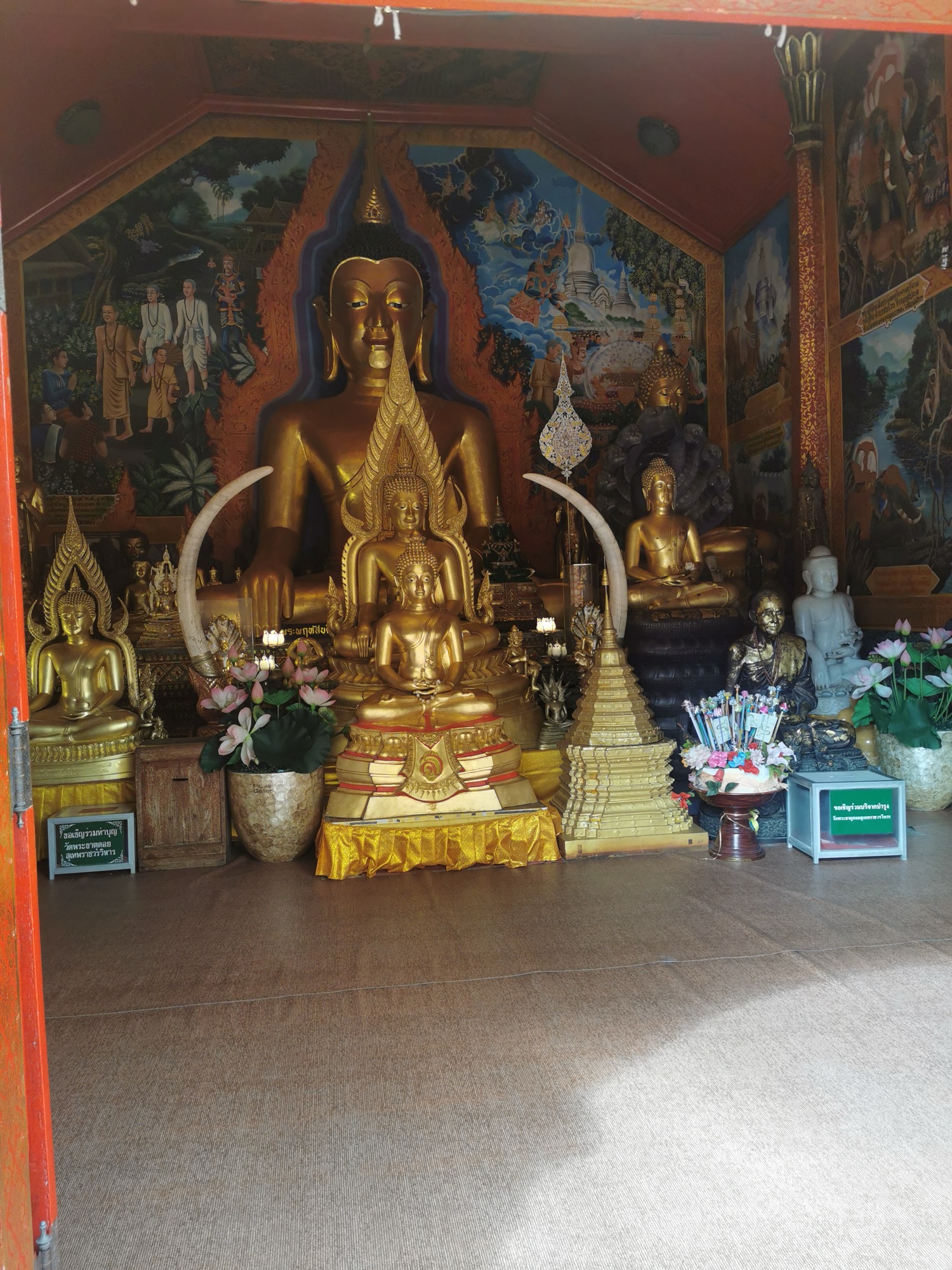 Altar con budas dorados y pinturas murales en Doi Suthep