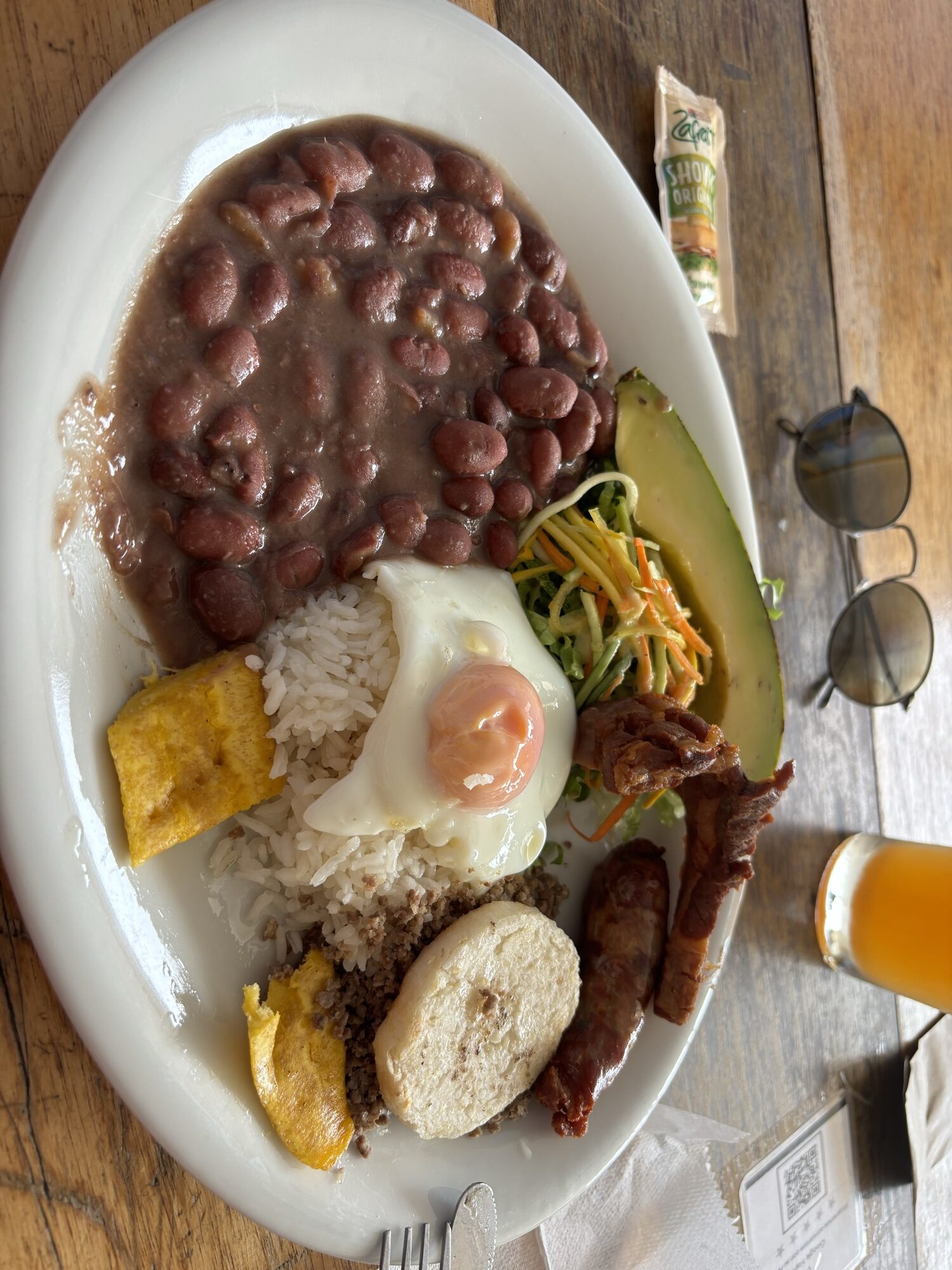 Bandeja paisa con frijoles, huevo frito, chicharrón, arepa, aguacate y plátano en un restaurante de Guatapé