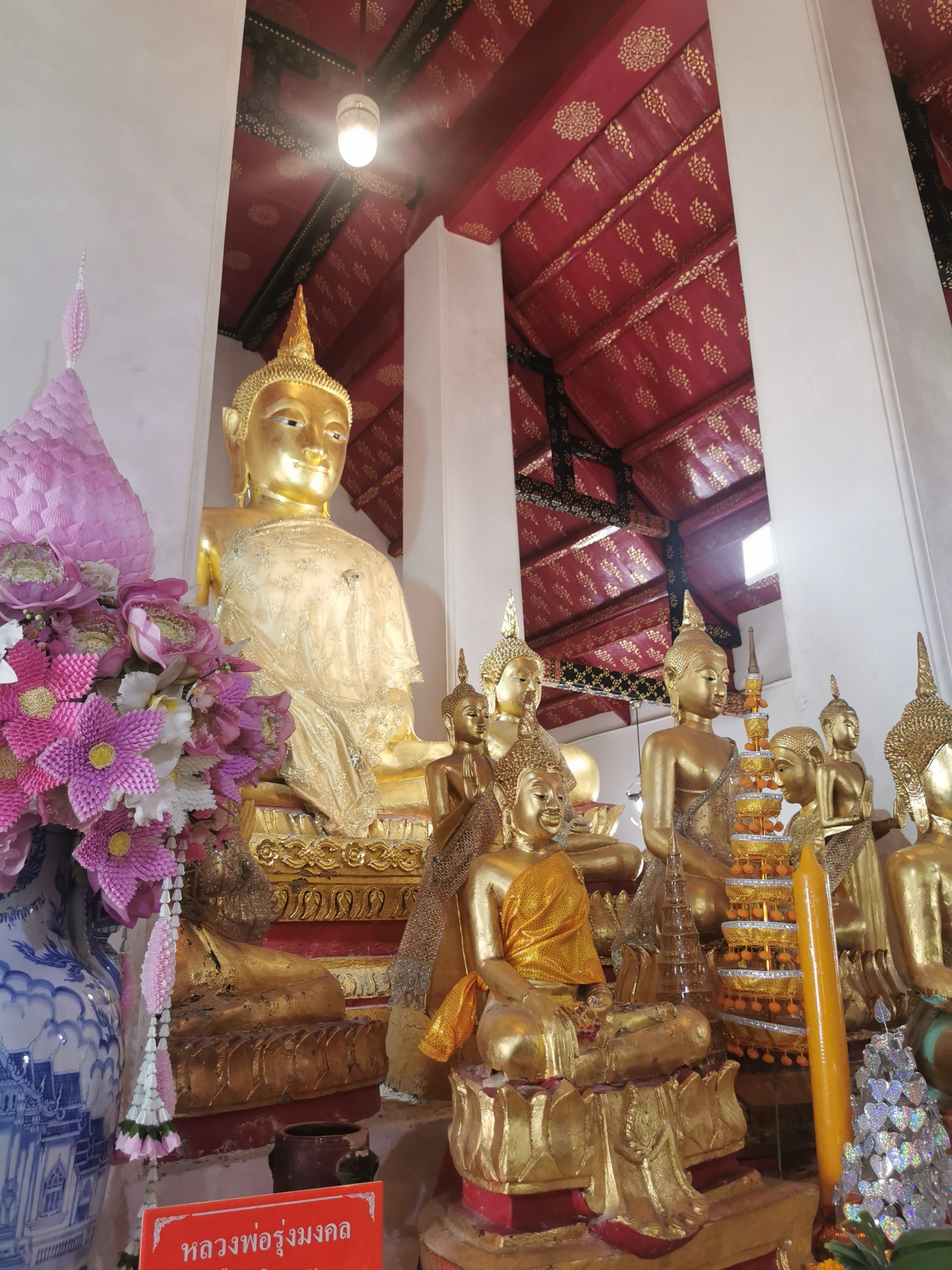 Budas dorados y flores en el interior de una sala del Wat Arun, en Bangkok