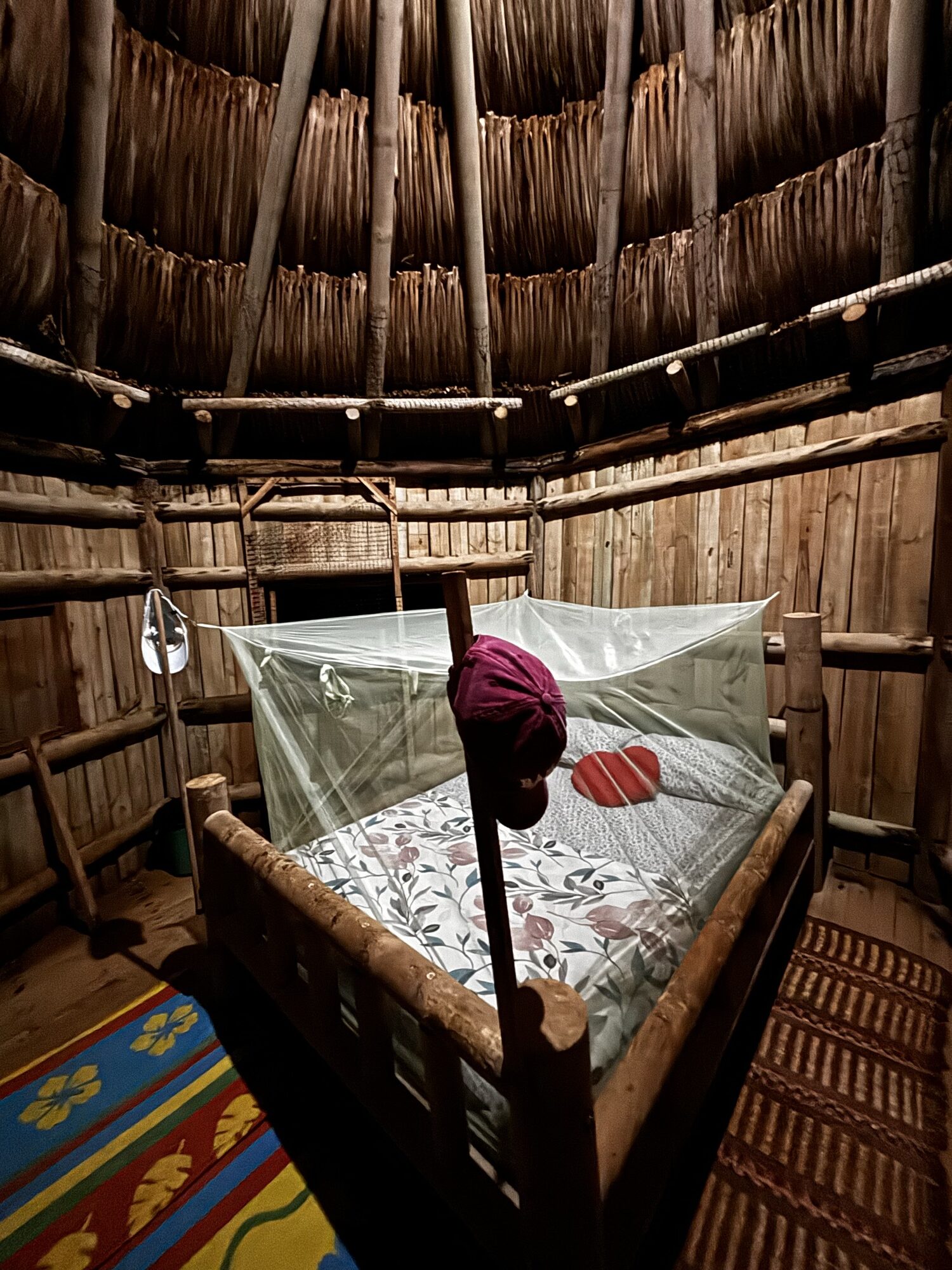 Cabaña de madera y palma con cama y mosquitera en Playa Brava Teyumakke
