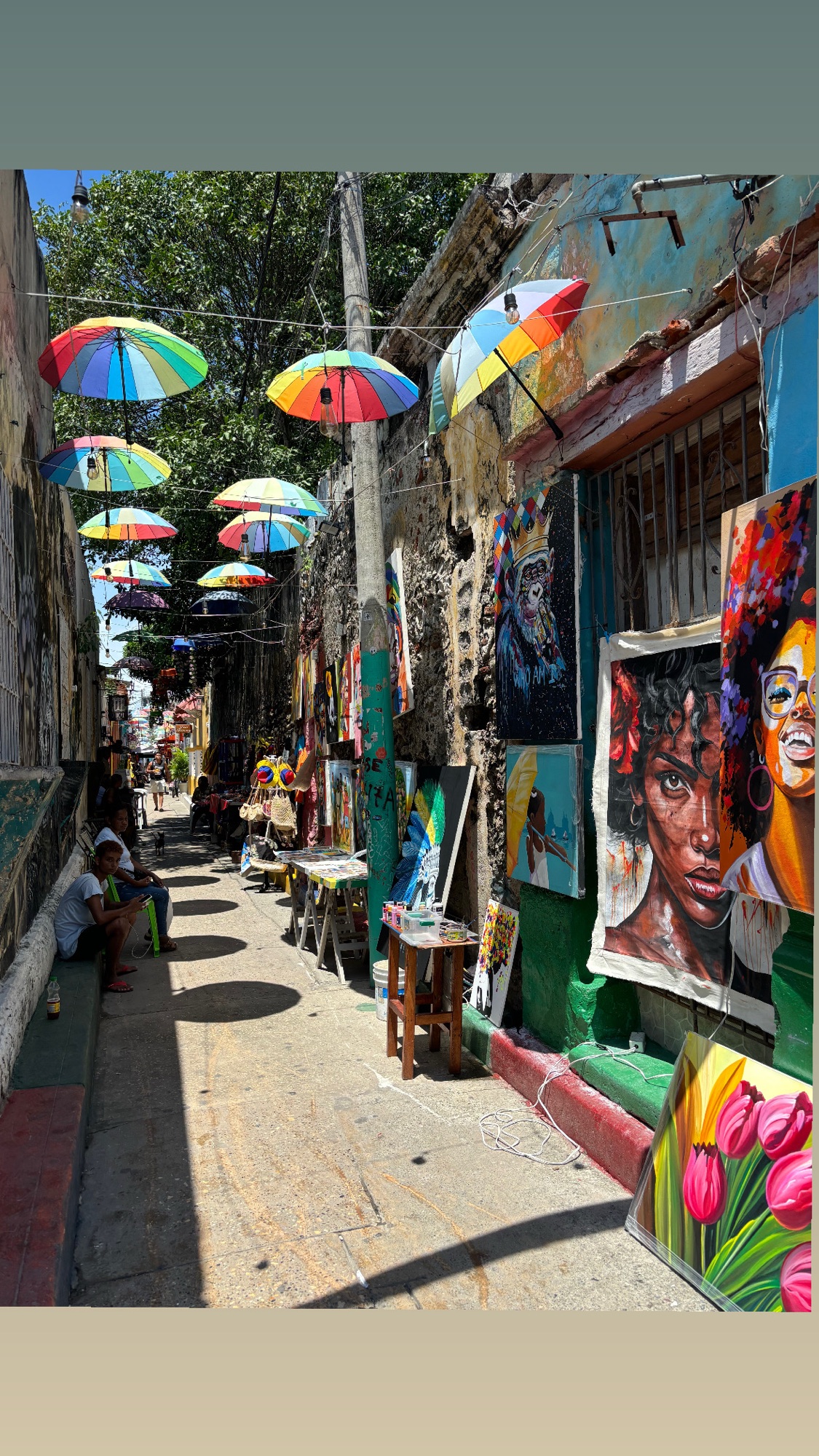 Calle de Getsemaní con paraguas de colores y cuadros de arte a la venta, en Cartagena