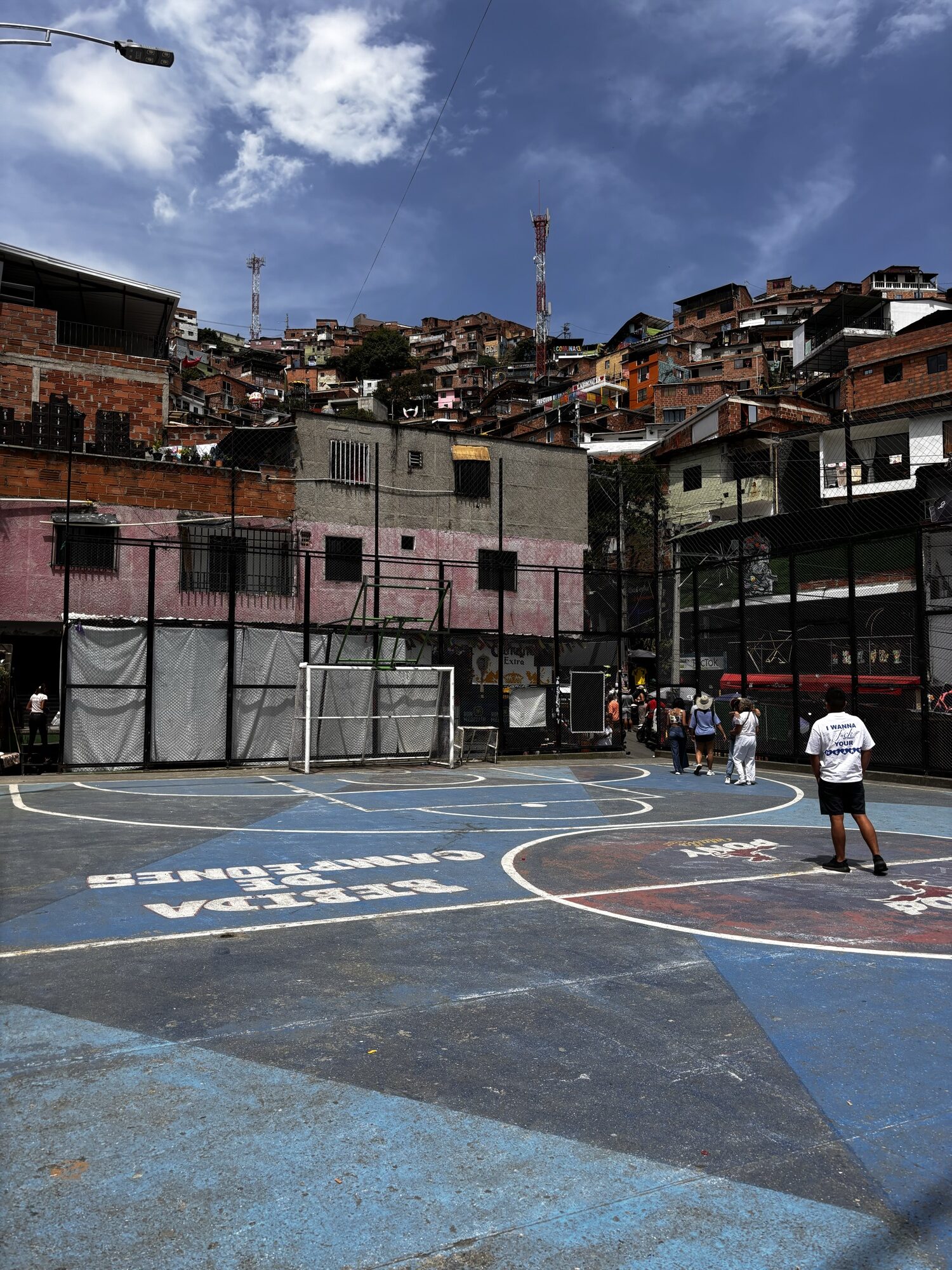 Cancha de fútbol pintada rodeada de casas de ladrillo en la Comuna 13 de Medellín