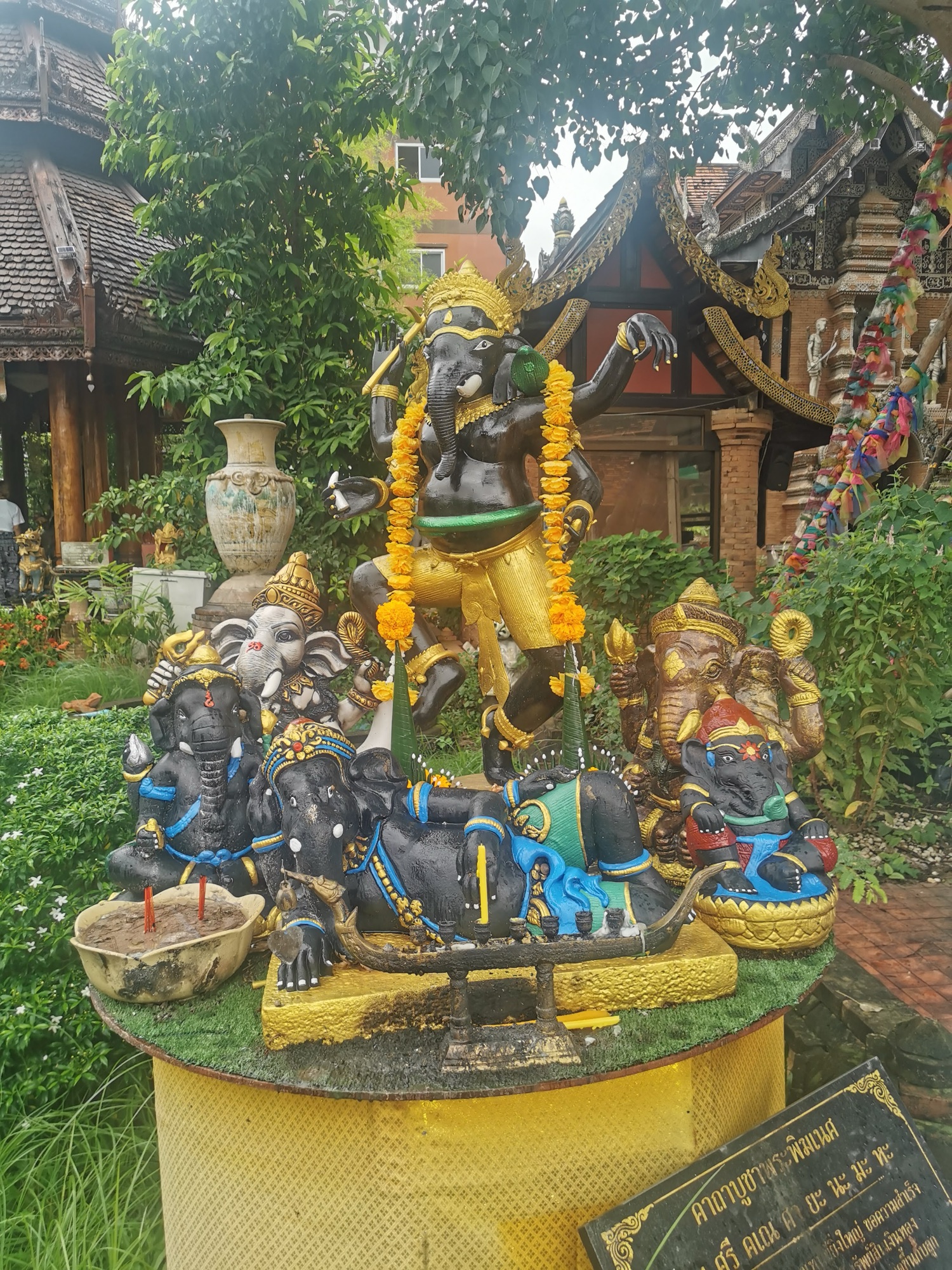 Estatuas de Ganesha con guirnaldas en el jardín de un templo de Chiang Mai