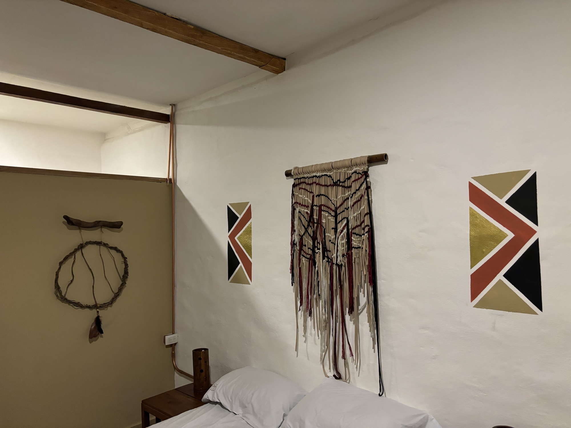 Habitación de estilo rústico con tapices y decoración geométrica en el Refugio del Jaguar, en El Poblado