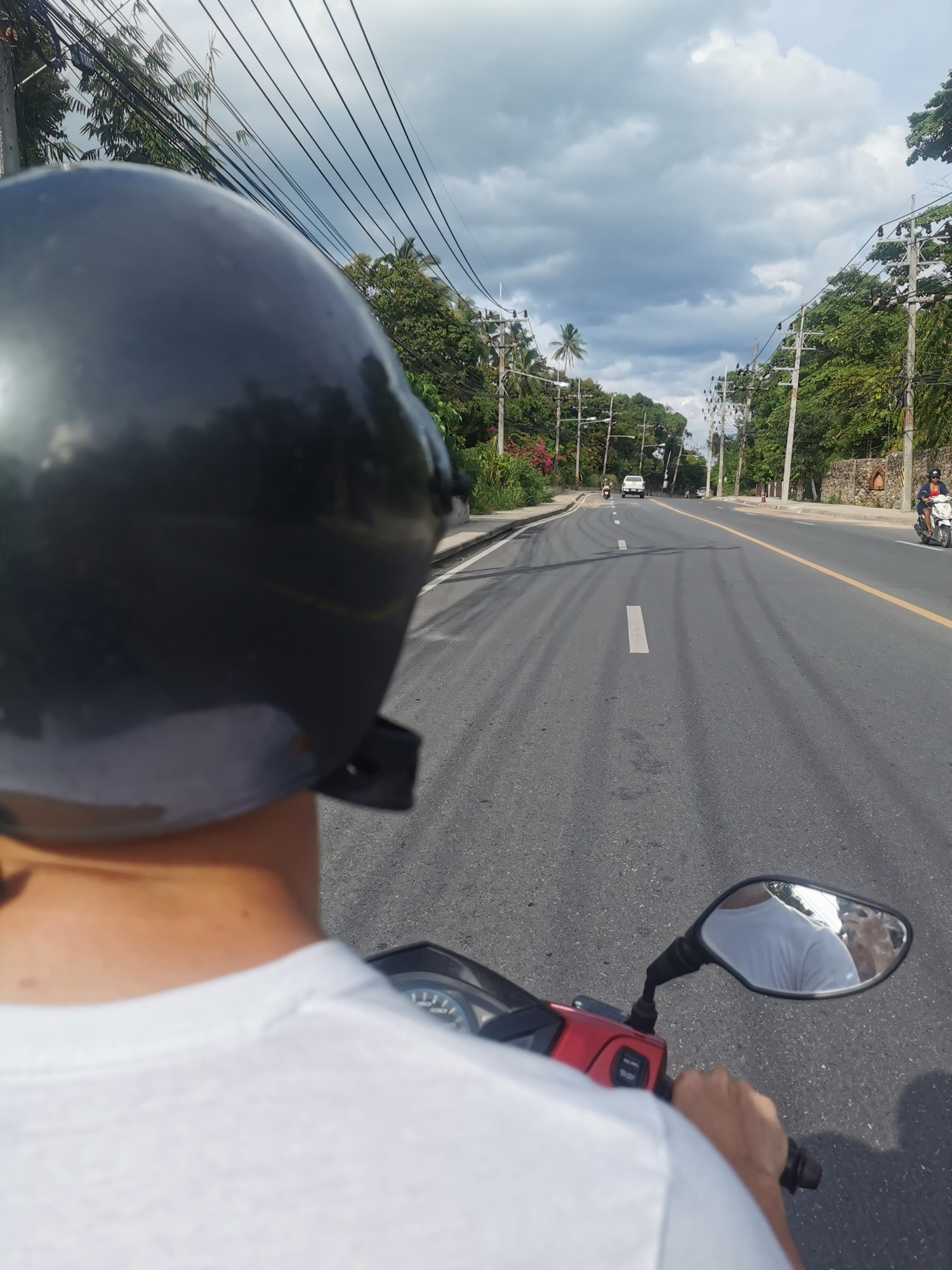 Recorriendo en moto una carretera de Koh Samui, con el casco en primer plano