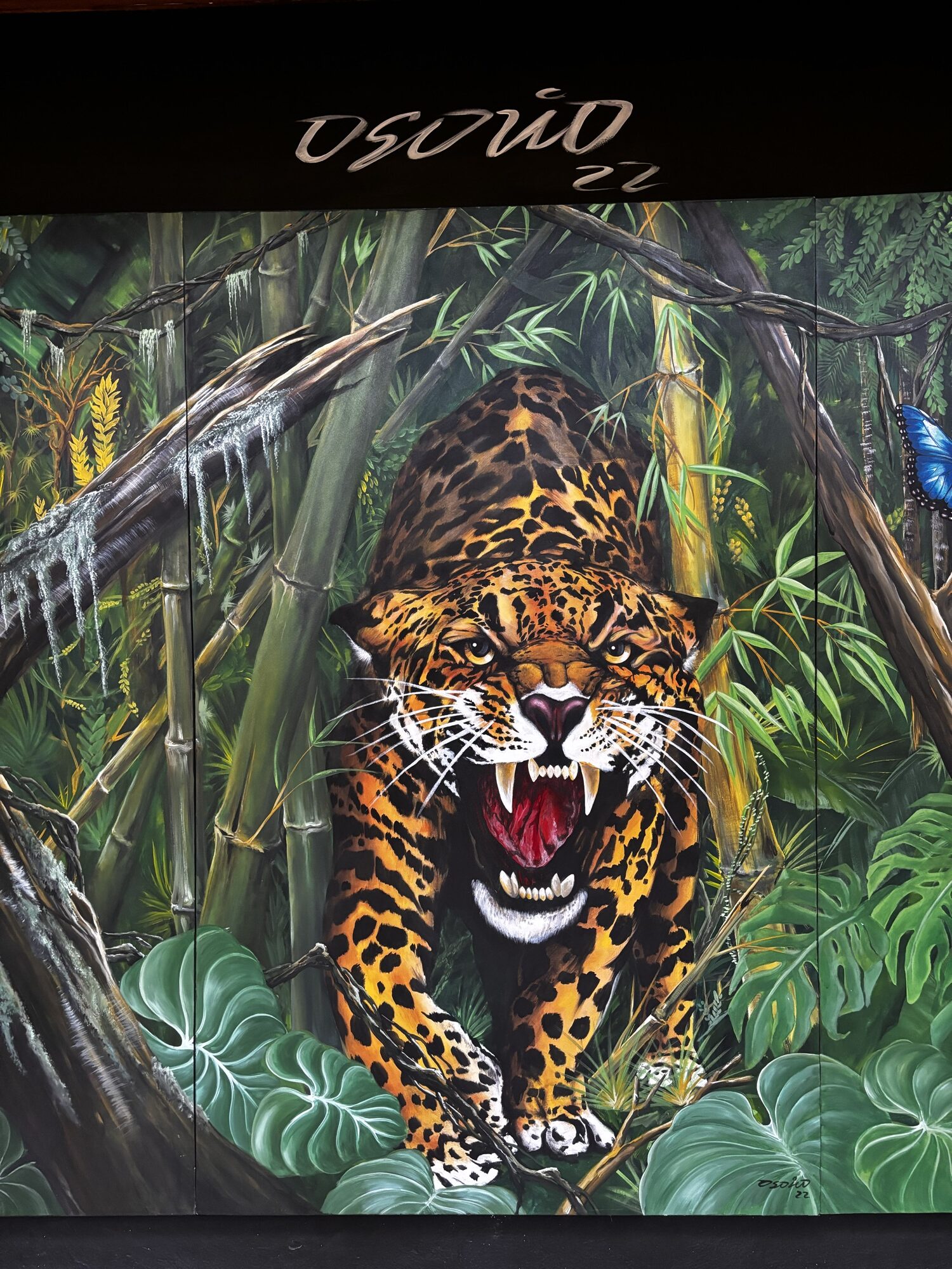 Mural de un jaguar entre la selva en el Refugio del Jaguar, en Medellín