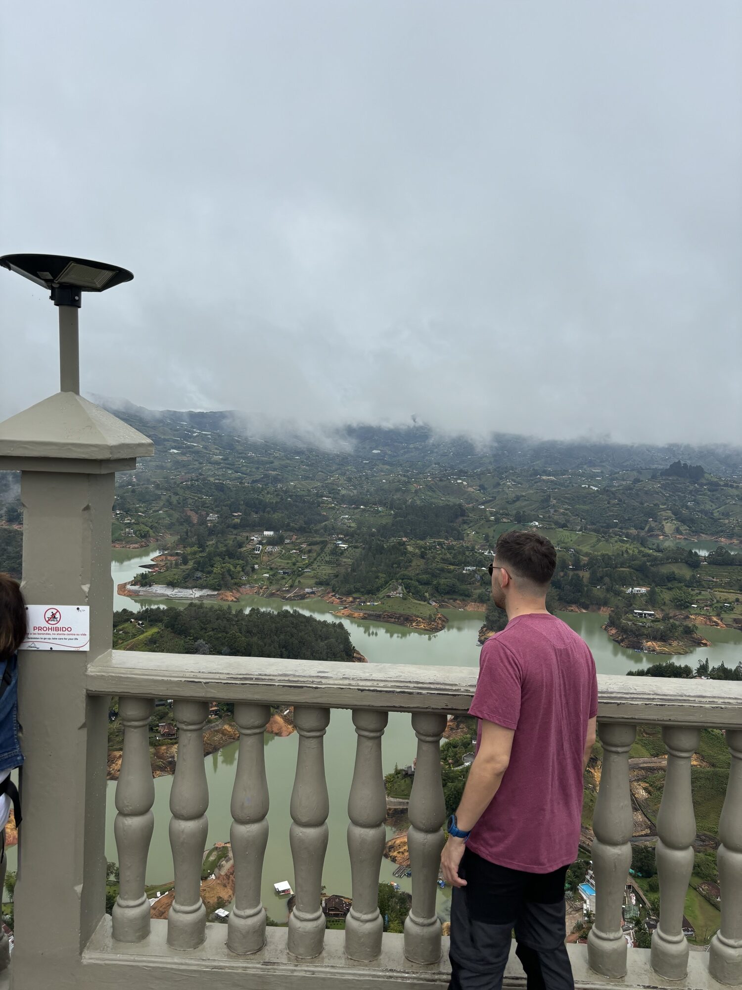 Pablo contemplando el embalse de Guatapé desde el mirador con balaustrada en lo alto de la Piedra del Peñol