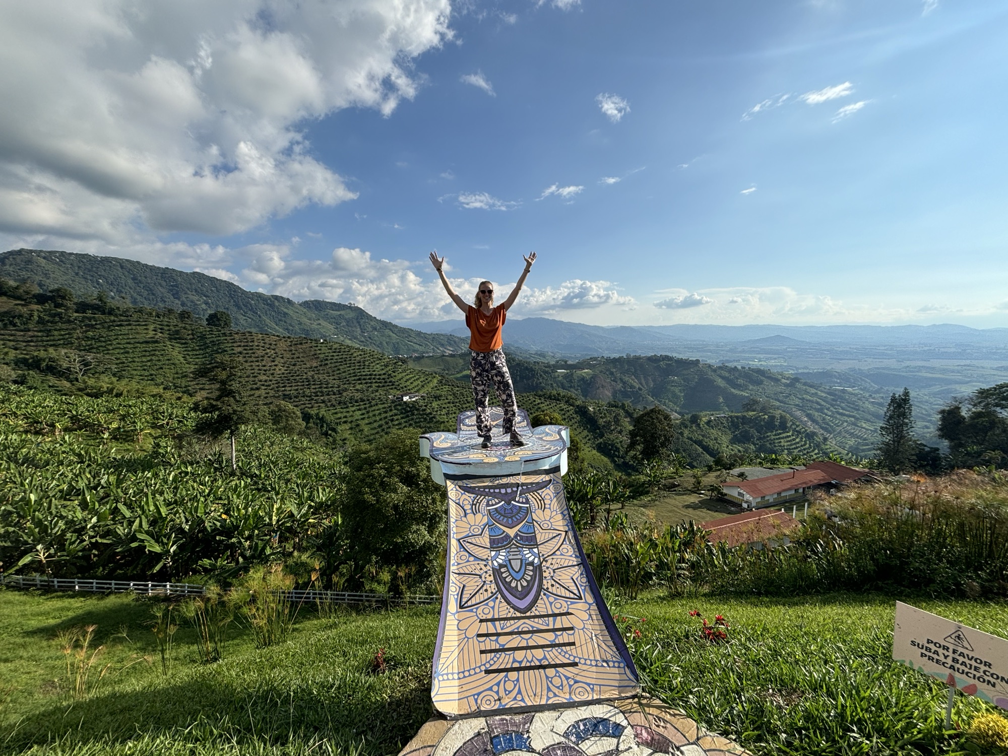 Pablo sobre el pedestal de mosaico del mirador de Buenavista con el paisaje cafetero al fondo