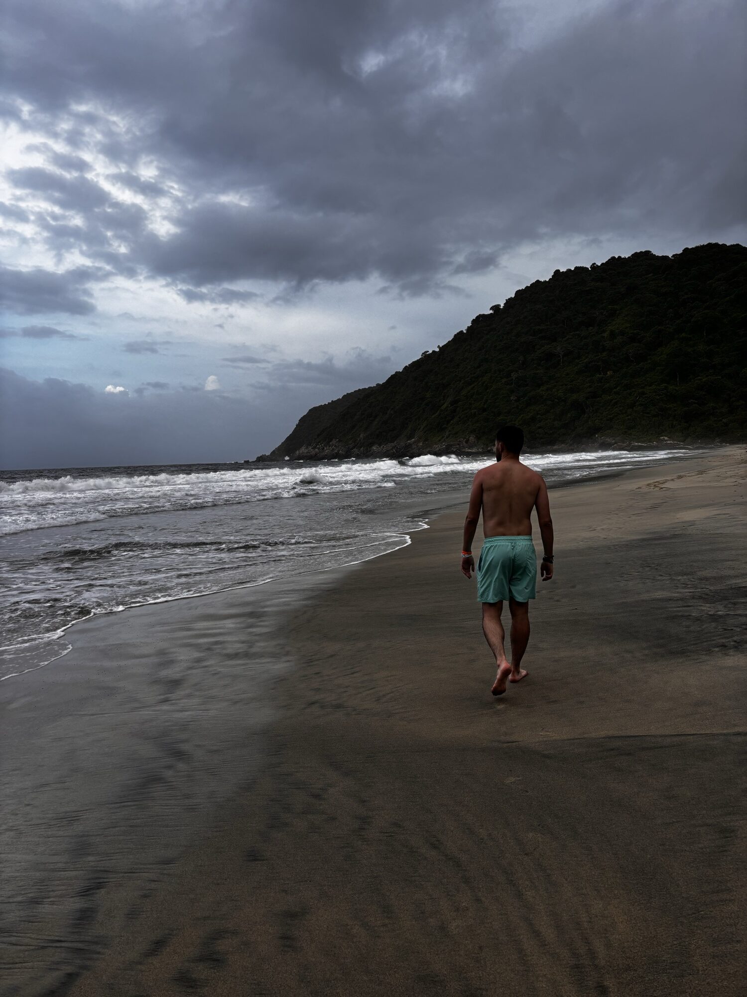 Pablo paseando por la arena de Playa Brava bajo un cielo de tormenta