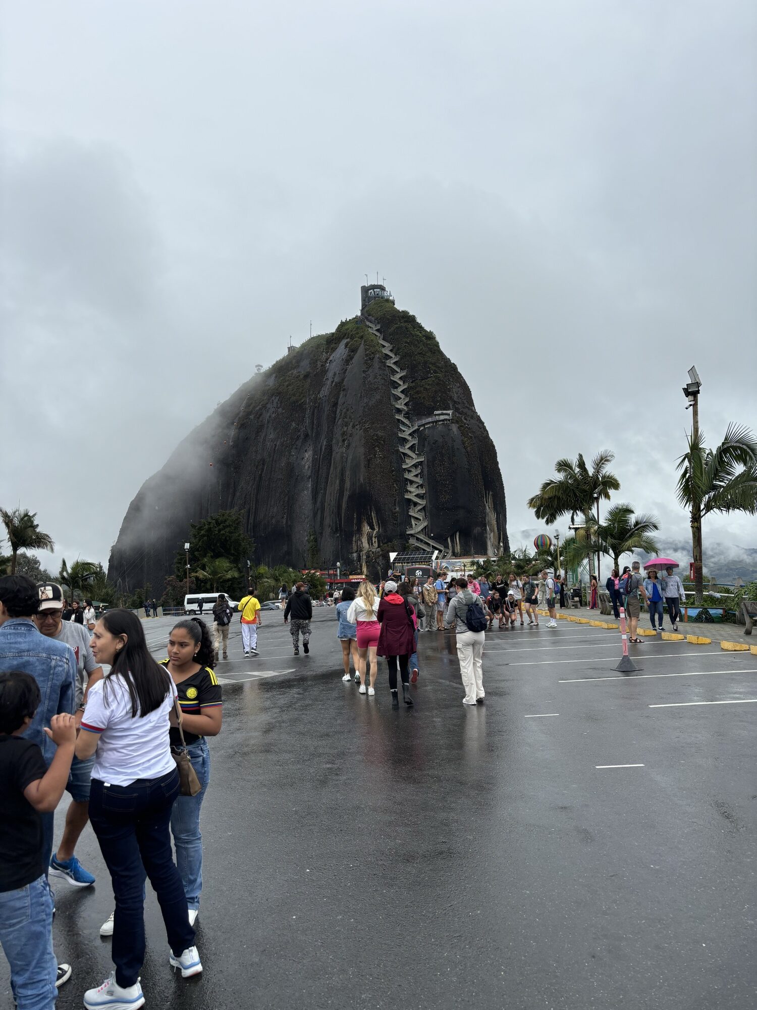 La Piedra del Peñol con su escalera de zigzag vista desde la explanada de acceso en un día nublado