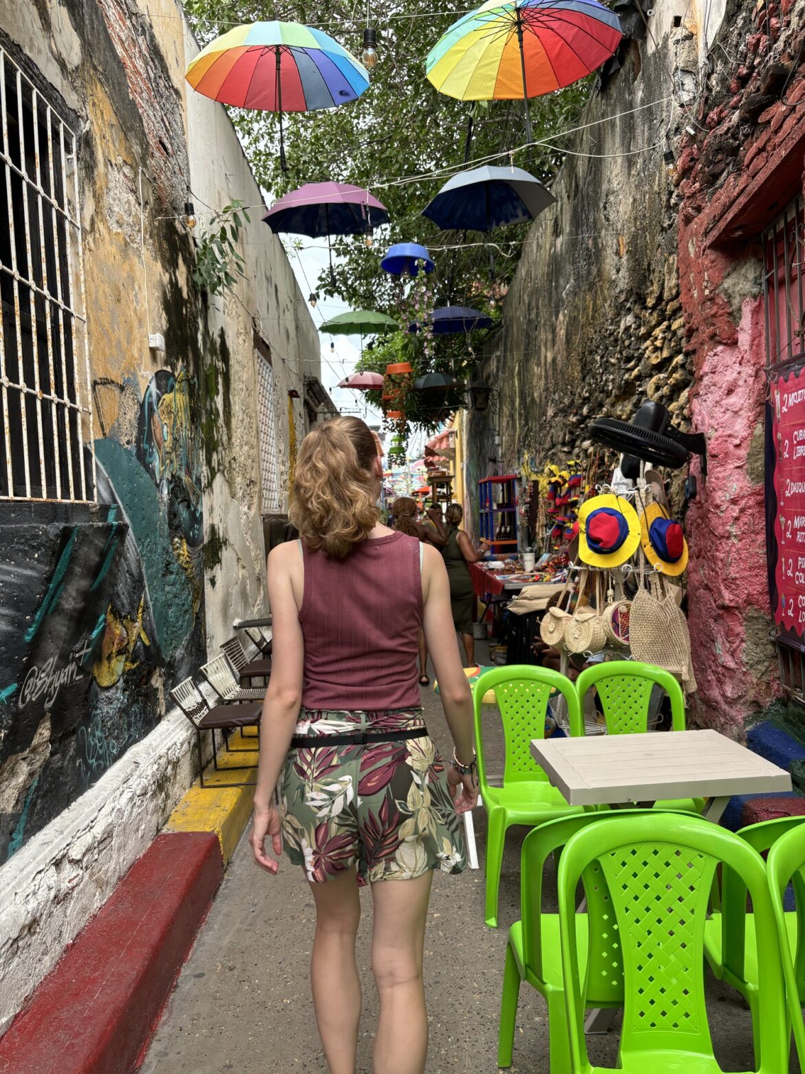 Laura paseando por el Callejón Angosto de Getsemaní bajo paraguas de colores