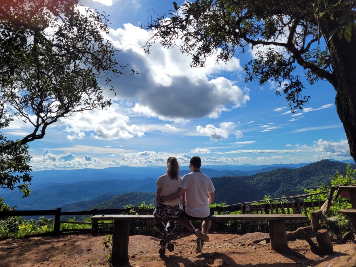 Laura y Pablo sentados en un banco del mirador de Doi Suthep, con las montañas de Chiang Mai al fondo
