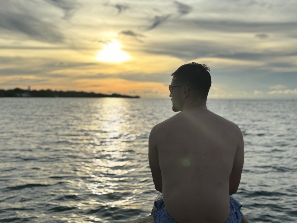 Pablo mirando la puesta de sol sobre el mar Caribe en Isla Grande, Islas del Rosario