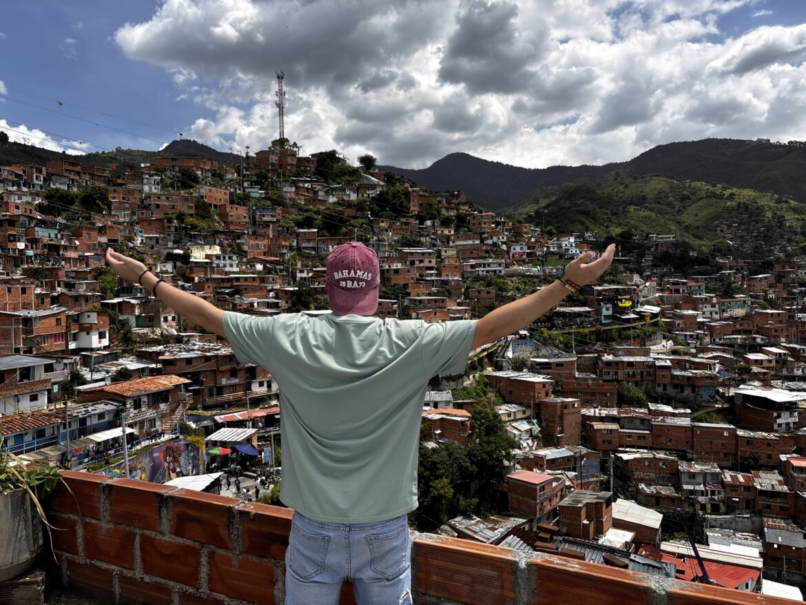 Pablo con los brazos abiertos frente a las vistas de la Comuna 13 de Medellín
