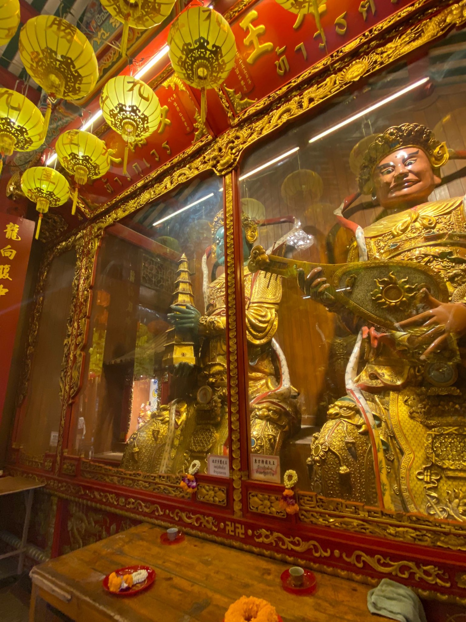 Figuras doradas y farolillos en un templo chino de Chinatown, en Bangkok