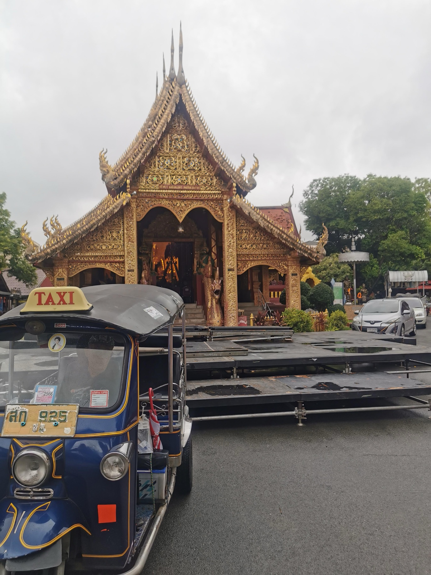 Templo dorado del centro de Chiang Mai con un tuk-tuk azul aparcado delante
