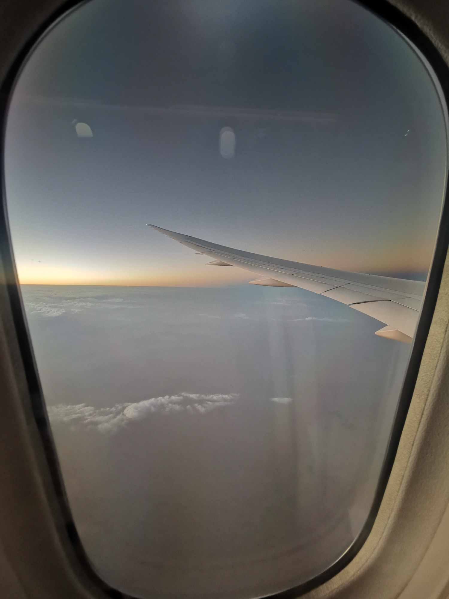 Vista desde la ventanilla del avión al atardecer, rumbo a Bangkok